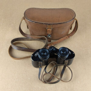 A classic pair of Carl Zeiss Jena Deltrintem 8x30 binoculars, finished in black with textured grip, supplied with the original brown leather case and leather neck strap.