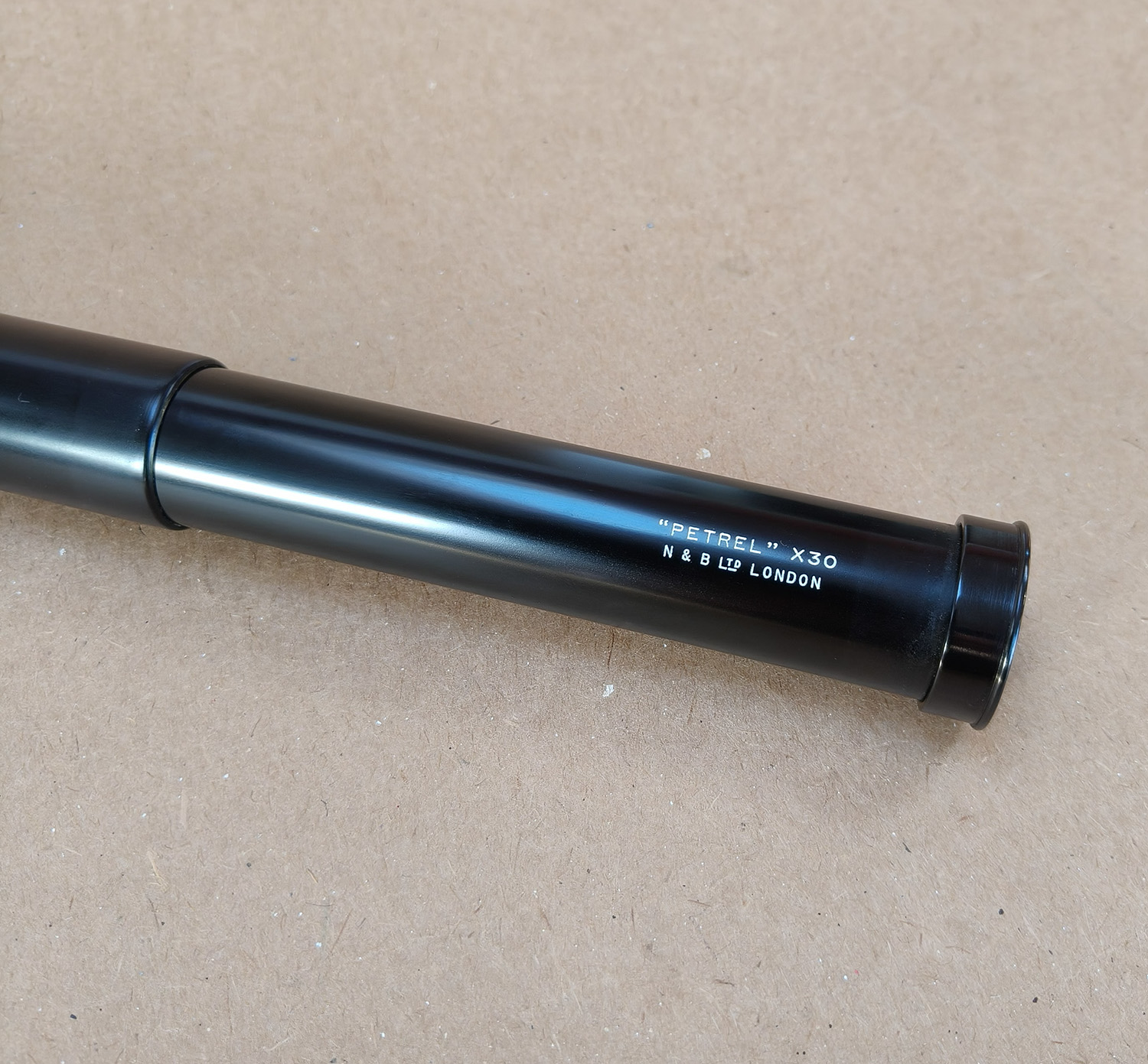 For sale is a vintage N & B Ltd London “PETREL” x30 handheld 2-draw telescope, complete with its original brown canvas and leather carry case. This is a classic British-made tubular spyglass with a 30× fixed magnification, designed for field use, birdwatching, nautical spotting, and general outdoor observation. The telescope features a black textured metal body, a smooth draw-tube extension, and quality optics typical of mid-20th-century British craftsmanship.